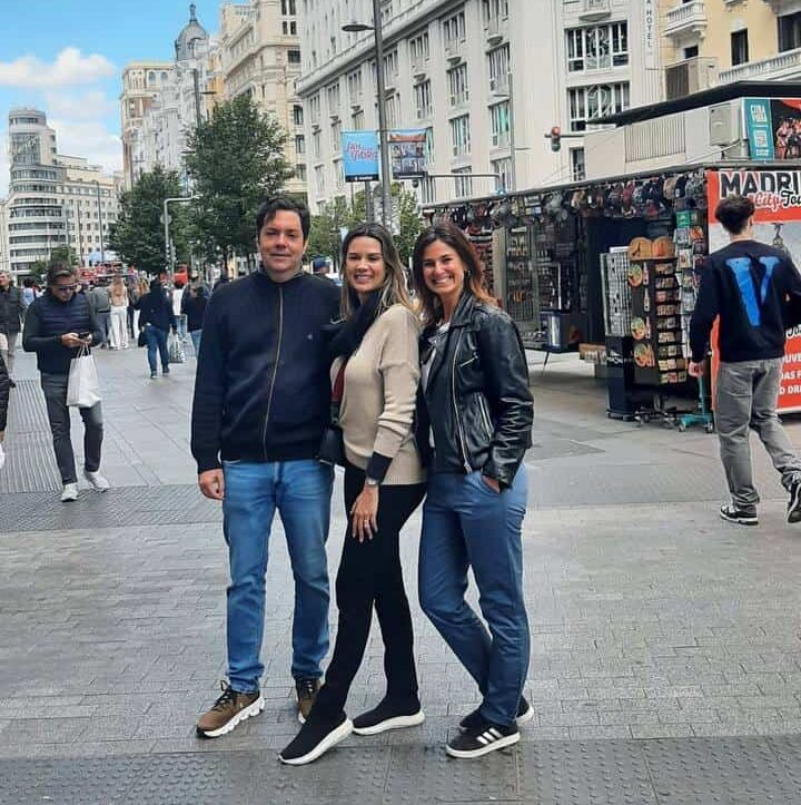 Thais e um casal de amigos estão posando para uma foto no meio do passeio.